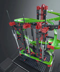 Dynamic M Set With 515 Parts For Four Buildable Models, Rotary Funnel, Sound Tubes, Cross Over, Five 90 Degree Curves, Steel Balls For Melodic Tones, Manual Chain Lift, A Solid STEM Toy Your Kids Will Totally Love displayed with green tracks and steel balls