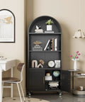 72 Inch Metal Arched Bookcase With Doors And Wheels, Industrial Black, Tall Storage Cabinet in living room setting with decor items.