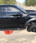 BotaBay 4 Ton Off-Road Air Jack With 8800 Lbs Capacity under a stranded black truck in sandy terrain for rescue.
