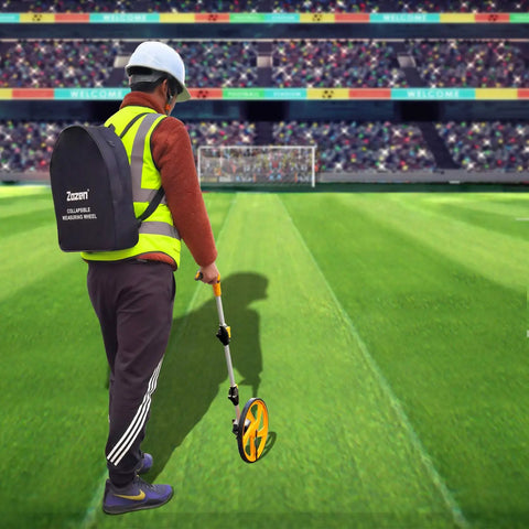 Person using Measuring Wheel For Feet And Inches With Mechanical Double Collapsible Design on a sports field.