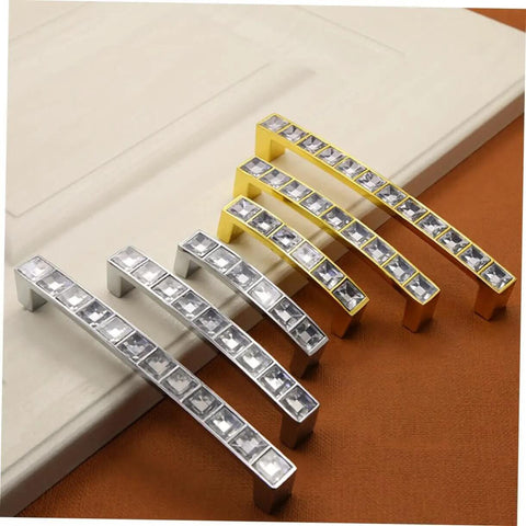 Crystal U Shaped Drawer Pull Handles In Bright Chrome With Screws on display, mix of silver and gold finish, elegant design