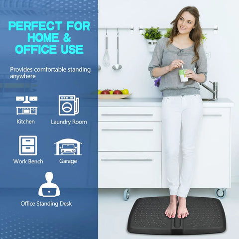 One Inch Thick Anti Fatigue Kitchen And Standing Desk Mat With Massage Ball And Massage Points Non Slip All Day Comfy Floor Mat for Feet Office And Home Black 17 By 28 By 1 Inches, showing a person standing on it in a kitchen setting.