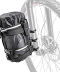 VersaCage Adventure Cage With Adjustable Mounting System And VersaMount Clamps And Straps holding a dry bag on a bike fork
