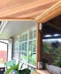 Outdoor setup with Beefy 17 Inch Gas Strut Set 35 lb lift supporting a wooden awning near a window with a TV