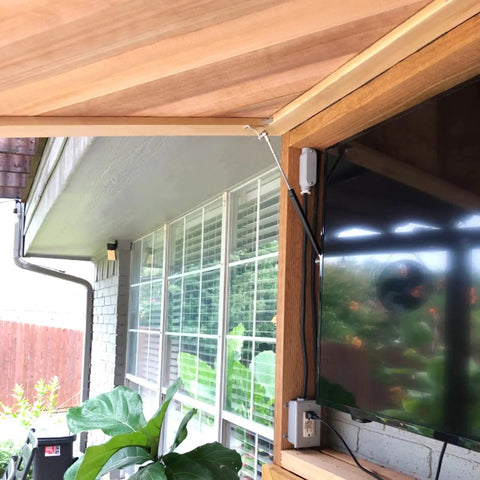 Outdoor setup with Beefy 17 Inch Gas Strut Set 35 lb lift supporting a wooden awning near a window with a TV