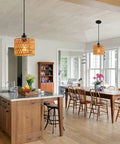 Total Vibe Hand Woven Rattan Pendant Light illuminating a kitchen island with a stylish boho design and natural wood elements.