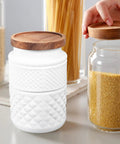 Vintage Embossed Glass Canisters With Airtight Wooden Lids Kick Up Your Pantry Game By Keeping Coffee Tea Grains Locked Tight 1800Ml Capacity Smooth Set Of 2 with wood lids on a kitchen counter.