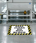 Keep Clear Do Not Block Sign 17 By 17 Inches 5 Pack Self Adhesive Waterproof Vinyl Safety Stickers installed on warehouse floor.