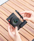 Hands holding D-LUX8 camera with Durable Aluminum Hand Grip, L Shape Bracket, Arca Quick Release Plate, and Anti Slip Microfiber Pad.