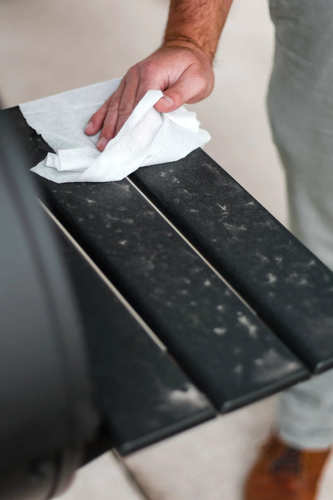 Close-up of Crocodile Cloth Grill wipe used on a black metal grill grate; white pre-moistened cloth.