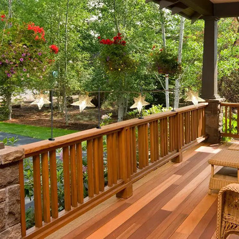 Dang Tough Deck String Light Poles Four Pack Heavy Duty All Metal Hooks For Fences And Wood Railings Easy Grip Adjustable Clamp holding star lanterns on a wooden deck railing.