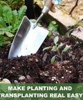 Beefy Stainless Steel Bend Proof Garden Trowel With Comfortable Wood Handle digging in soil by a plant