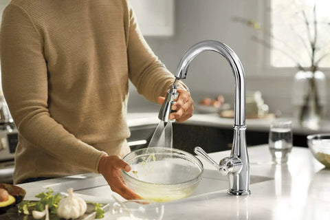 Person using Elmhurst Do-It-All Single-Handle Kitchen Faucet With Pull-Down Sprayer, Chrome Finish, washing bowl in a modern kitchen