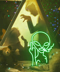 Scene with Green Alien LED Neon Sign and silhouettes in a cozy setup. Green Alien LED Neon Sign Wall Decor For Bar Pub Man Cave Game Room Hip Hop Party And Bedroom Aesthetic Hangable Neon Light With Acrylic Backboard And Easy Power Supply Perfect Vibe Booster For Any Space.