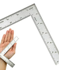 Solid As A Rock Stainless Steel L Shaped Square Ruler Featuring Dead On 4 By 6 Inch Dual Side Etchings shown with hand for scale.