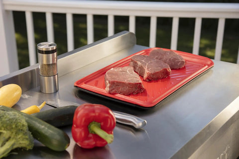 Red tray for raw meat on grill with vegetables, part of Grilling Prep And Serve Trays Set 17 x 10.5 Inch Dual Nesting Trays Red For Raw Meat And Black For Cooked Food Dishwasher Safe BPA Free Safe Food Handling Fits Up To 6 Burgers Perfect BBQ Accessories.