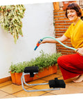Portable Gardening Kneeler And Seat With Wearable Foam Pad And Non Slip Base Heavy Duty Workhorse Garden Bench next to woman watering plants