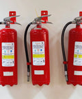 Universal Fire Extinguisher Wall Mount Kit For 5 To 40 Lb Units Includes Screws Gaskets Self Adhesive Safety Sign And Four Mount Hooks Easy Install Keeps Fire Extinguishers Secure In Home Garage Or Workshop installed with three red extinguishers on a wall.