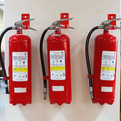 Universal Fire Extinguisher Wall Mount Kit For 5 To 40 Lb Units Includes Screws Gaskets Self Adhesive Safety Sign And Four Mount Hooks Easy Install Keeps Fire Extinguishers Secure In Home Garage Or Workshop installed with three red extinguishers on a wall.