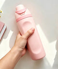 Hand holding pink Insulated Stainless Steel Water Bottle With Built-In Straw, Leak-Proof Seal, BPA-Free, Perfect For Sports And Travel.