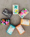 PreparaKit kid travel first-aid pouch set, 7 colorful fabric pouches arranged in a circle.