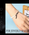 Matte black swivel snap hooks and jump rings for jewelry making displayed with a bracelet on a hand.