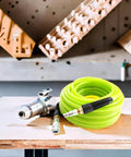 Coiled Reinforced Polyurethane 3/8 Inch ID Air Hose, 100 Ft, 300 PSI, wear-resistant green with coupler and plug on workspace.