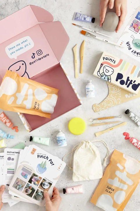 Air Dry Clay Kit For Adults Beginners Home Pottery Craft Set with tools, paints, brushes, sealant, and guides on a table.