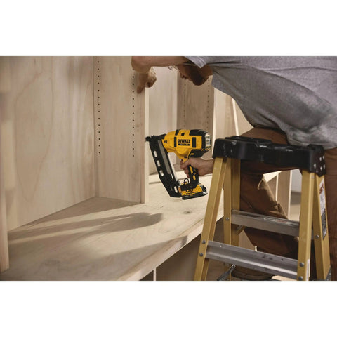 Person using 20V Cordless Angled 16 Gauge Finish Nailer Tool Only, Brushless Motor on wooden cabinet trim