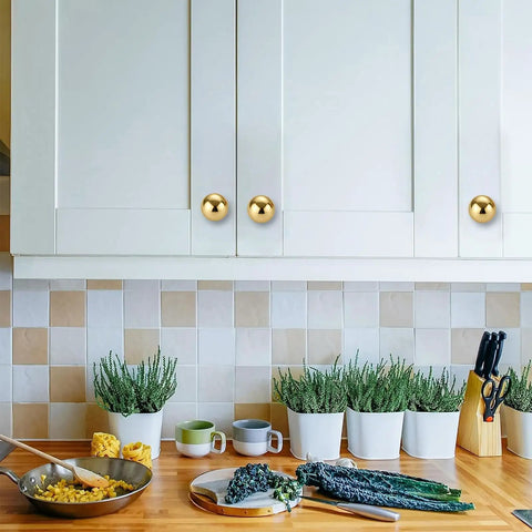 Two Pack One And A Quarter Inch Unlacquered Brass Cabinet Knobs Round Pulls on white kitchen cabinets above countertop
