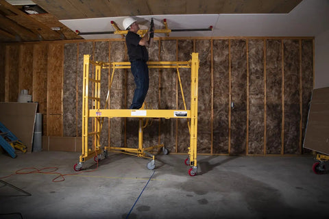 Heavy Duty Adjustable Work Platform Featuring Locked Safety Rails Acts As A Slick Scaffolding Alternative That Rolls Straight Through Standard Doorways For Tight Indoor Or Outdoor Projects Up To Eleven Feet High