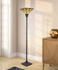 70 Inch Tiffany Torchiere Floor Lamp With Antique Mission Style Stained Glass Shade, dark bronze base, in living room corner.
