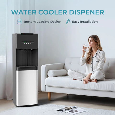 Bottom Loading Water Cooler Dispenser With Cold Warm And Hot Go To Settings For 5 Gallon Bottle LED Display Light And Child Lock Built For Home Office Apartment Black next to woman drinking water on couch.