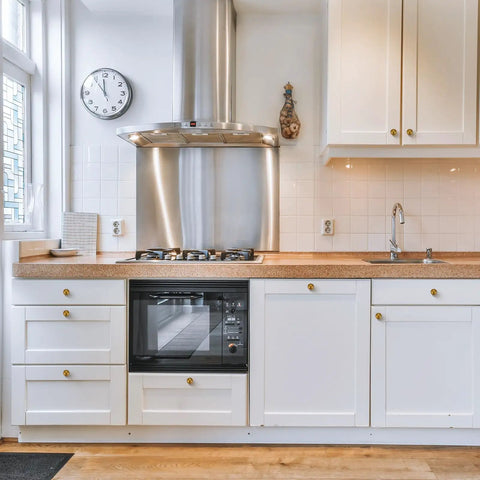 Antique Brass Round Cabinet Knobs 6 Pack installed on white kitchen cabinets with wooden countertop, modern kitchen decor.