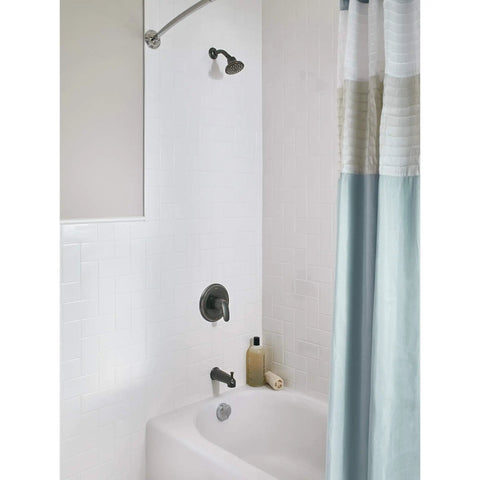 Colony Pro Tub And Shower Trim Kit with bronze finish installed in a white tiled bathroom, showing showerhead and tub faucet.