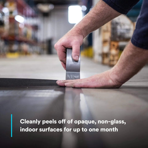 Person using Heavy Duty Duct Tape, Silver, 1 Pack, 1.88 in x 60 yd x 9.0 mil, on warehouse floor for sealing.