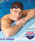 Man wearing AquaBlock Silicone Ear Plugs For Swimming And Water Sports, leaning on pool edge, showing waterproof comfort fit, purple.