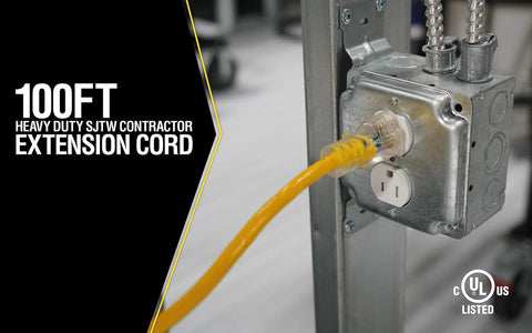 100-foot yellow extension cord plugged into metal electrical box on job site, labeled Heavy Duty SJTW Contractor Extension Cord.
