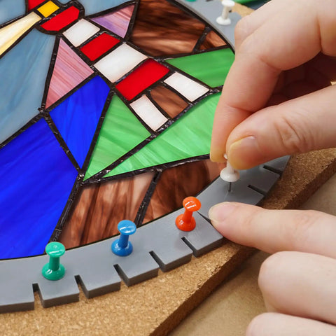Solid Game Changing Flexible Silicone Layout Blocks 12 Pack With Push Pins, showing a hand placing a push pin in stained glass layout.