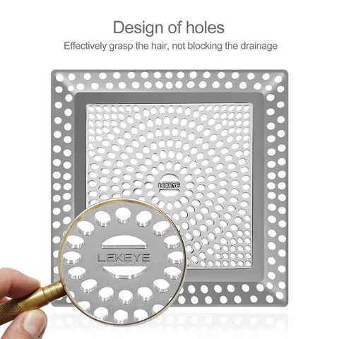 Close-up of stainless steel shower drain hair catcher and strainer cover, showing elliptical holes blocking hair and debris.