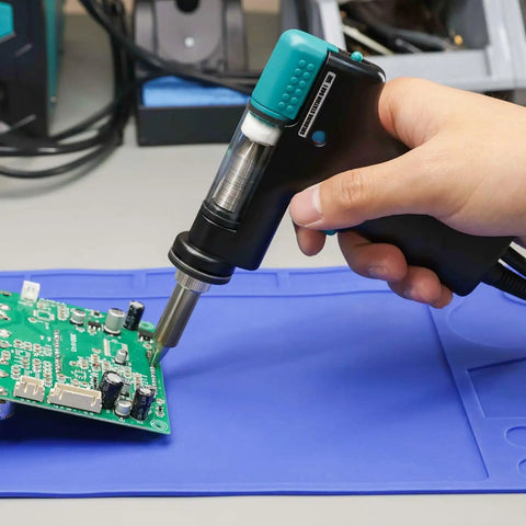 Hand holding Replacement Desoldering Suction Gun Handpiece for 948D Series Desoldering Stations 948D-I III IV V on circuit board