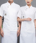 Killer Short Sleeve Chef Coat With Super Breathable Moisture Wicking Fabric And Roomy Utility Pockets, worn by two chefs.