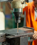 Beast Quarter Inch Cobalt Drill Bit Set used on metal sheet, industrial worker operating drill press