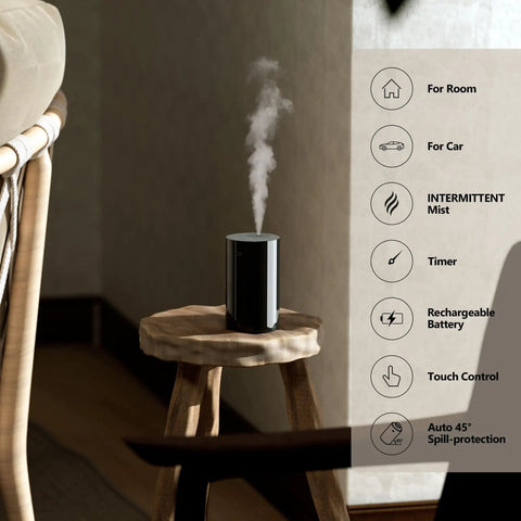 Waterless Essential Oil Diffuser Starter Kit With Four 10mL Hotel Scent Fragrance Oils Battery Operated Portable Diffuser For Home Car Office AN8 Kit Black on wooden stool, emitting mist.