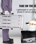 Foldable Aluminum Work Platform 30 by 12 by 20 Inches, Heavy Duty Stool Ladder With 330 Lb Load Capacity, Non Slip Feet, Perfect For Vehicle Washing, Cleaning, Painting, Decorating, And Home Projects. Folded aluminum platform being carried and stored in a car trunk.