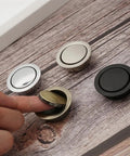 Person using hidden door handle set recessed metal pulls for cabinets and drawers, invisible round wardrobe shoe pulls in assorted colors