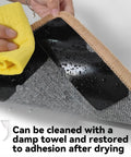 Non Slip Rug Grippers Set For Area Rugs, showing black reusable tape pad under a rug being wiped with a damp cloth.