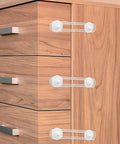 Three white safety locks from 4 Pack Kid Proof Cabinet Locks For Drawers And Furniture, Flexible Adhesive Strips For Easy Install on wooden dresser