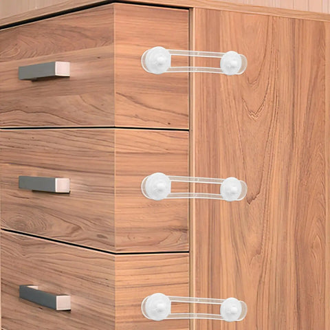 Three white safety locks from 4 Pack Kid Proof Cabinet Locks For Drawers And Furniture, Flexible Adhesive Strips For Easy Install on wooden dresser