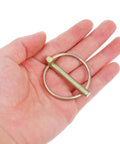 Get Your Yard Gear Fixin' With These 12 Heavy Duty Carbon Steel Retaining Pins Featuring Ring Locks For Tractors Mowers And Trailers To Keep Everything Secure And Rust-Free In The Dirt, shown in hand.